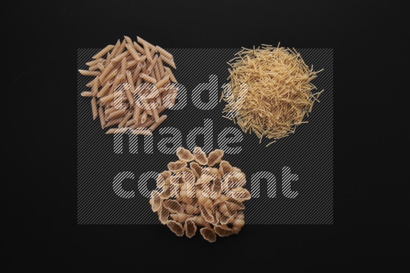 Different pasta types in bunches on black background