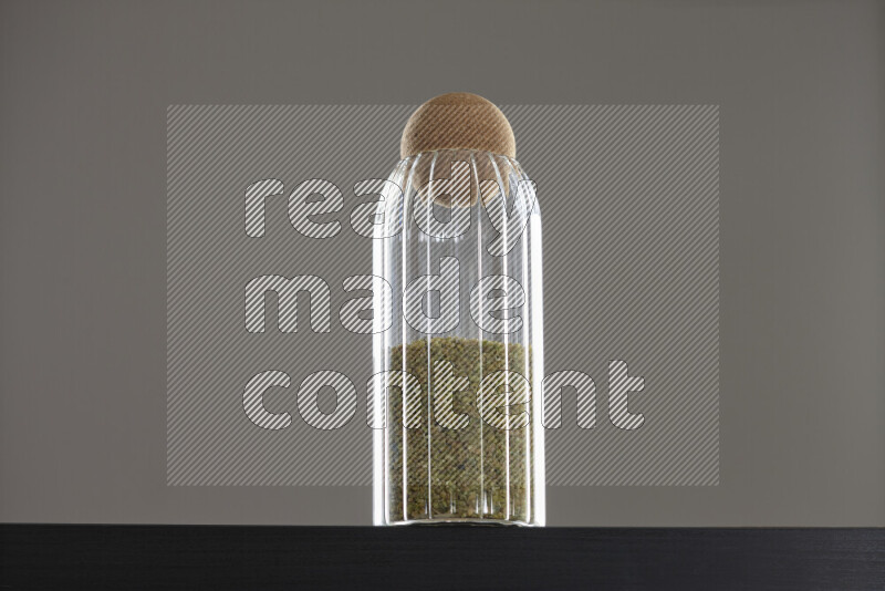 Freekeh in a glass jar on black background