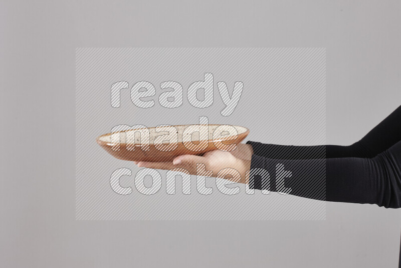 A woman in black abaya holding different pottery essentials in different positions