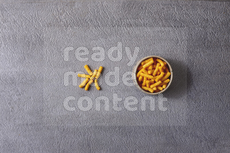 Assorted snacks in pottery bowls on grey background