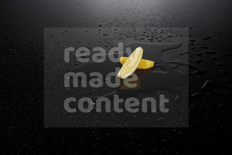 Lemon wedges with water drops, and droplets on black background