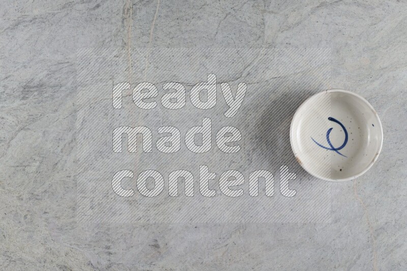 A white pottery bowl on grey marble background