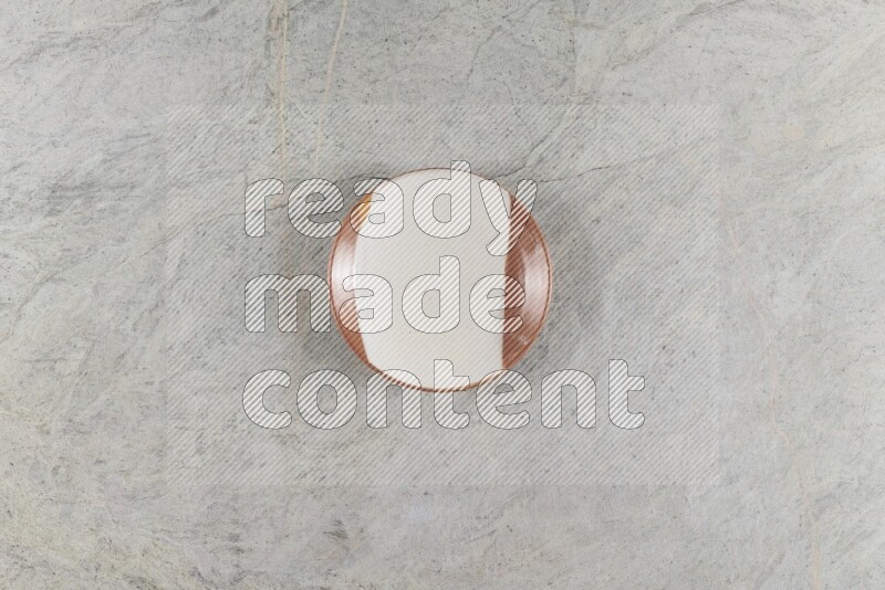 A multicolored pottery plate on grey marble background