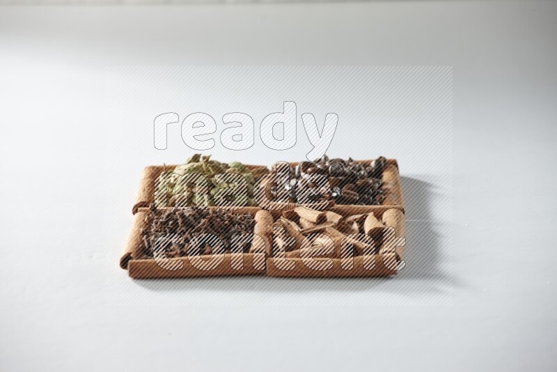 4 squares of cinnamon sticks full of coffee beans, cinnamon, cloves and cardamom on white flooring