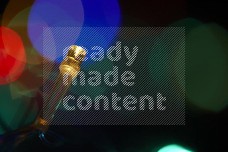 Light bulbs glowing against backdrop of multicolord bokeh