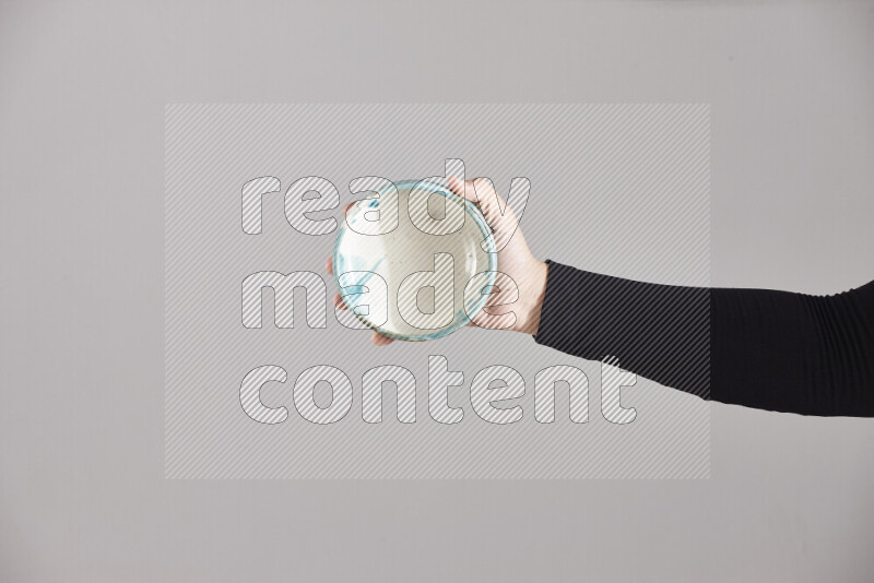 A woman in black abaya holding different pottery essentials in different positions