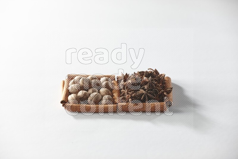 2 squares of cinnamon sticks full of star anise and nutmeg on white flooring