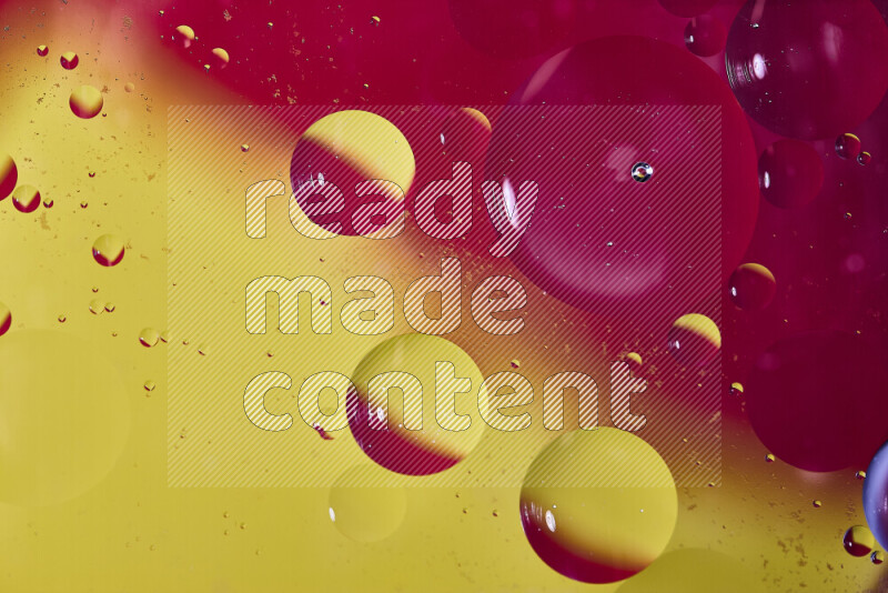 Close-ups of abstract oil bubbles on water surface in shades of red and yellow