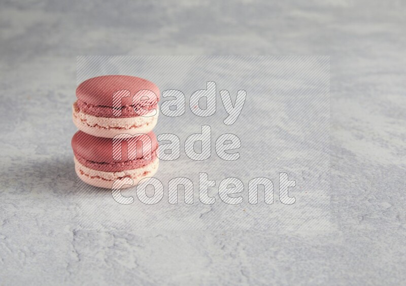 45º Shot of two Pink Litchi Raspberry macarons  on white  marble background
