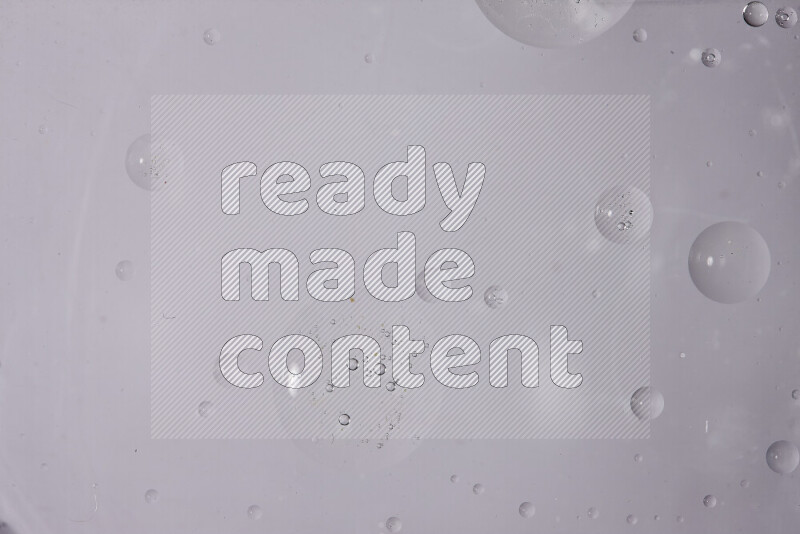 قطرات من الزيت على سطح الماء على خلفية بيضاء