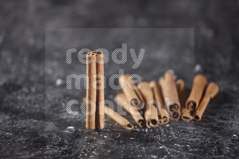 Cinnamon sticks on a textured black background