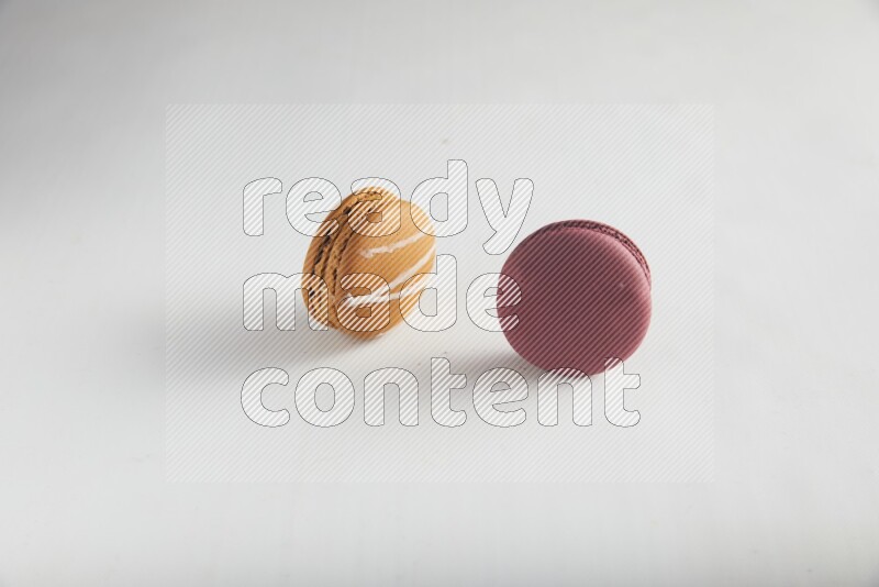 45º Shot of of two assorted Brown Irish Cream, and Red Cherry macarons on white background