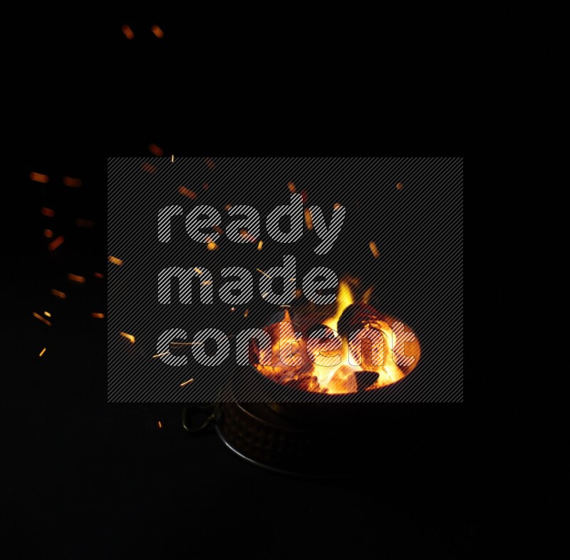 Coal cubes on fire in metal pan