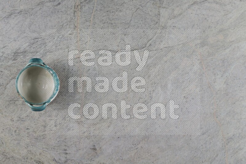 وعاء فخاري متعدد الألوان على خلفية من الرخام الرمادي