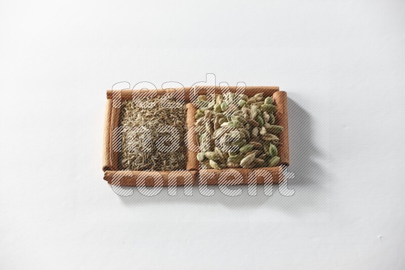 2 squares of cinnamon sticks full of cardamom and cumin on white flooring