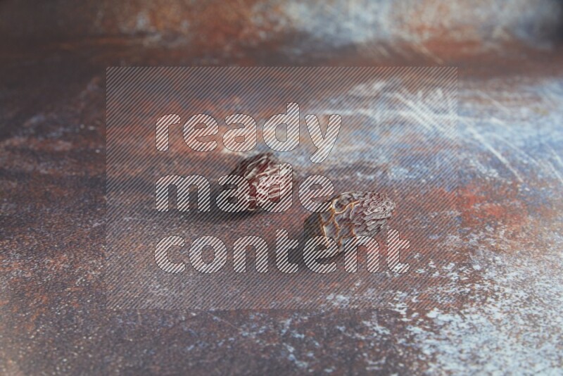 two madjoul dates on a rustic reddish background