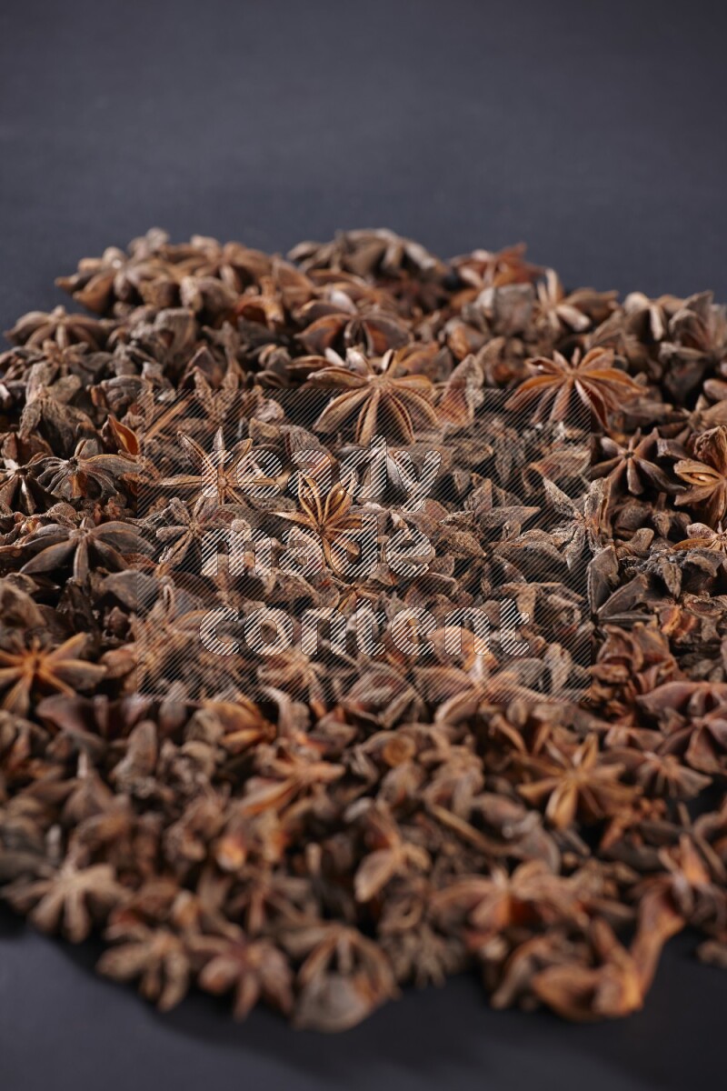 Star Anise herbs fill the frame on black flooring