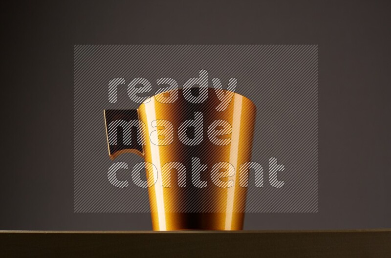Low angle shot of a golden cup on grey background