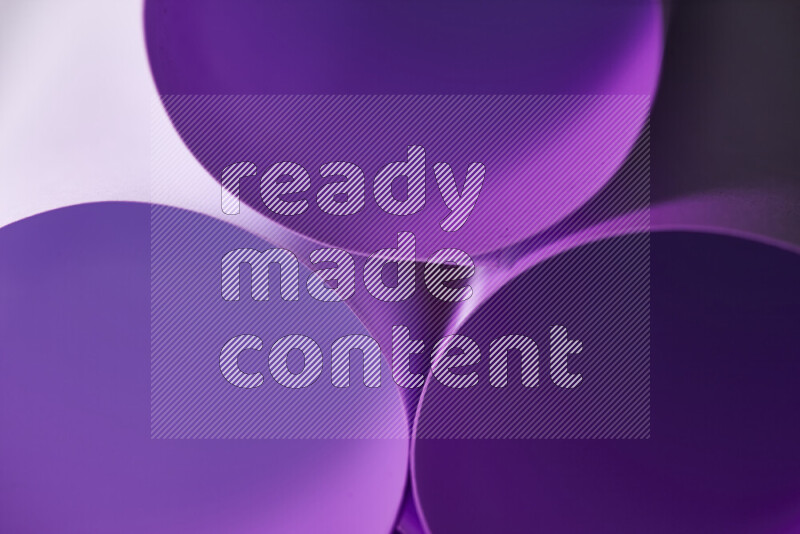 The image shows an abstract paper art with circular shapes in varying shades of purple