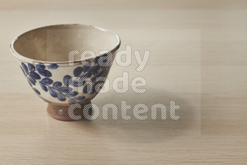 A decorative pottery bowl on light wooden background