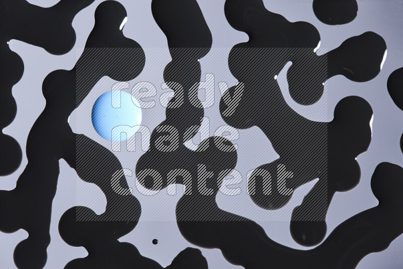 Close-ups of abstract blue and black paint droplets on the surface