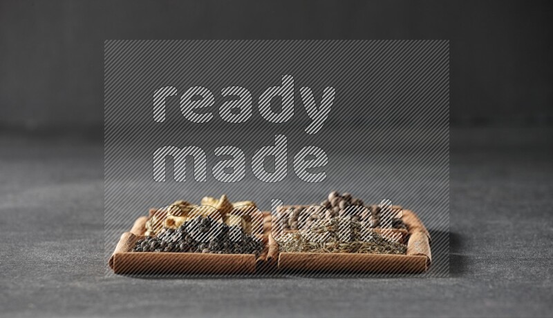 4 squares of cinnamon sticks full of black pepper, cumin, allspice and turmeric fingers on black flooring