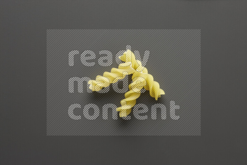 Fusilli pasta on grey background