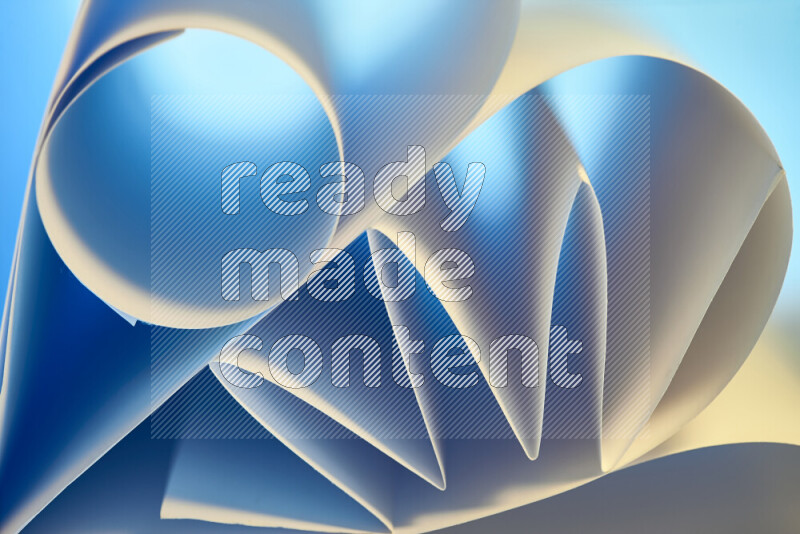 An artistic display of paper folds creating a harmonious blend of geometric shapes, highlighted by soft lighting in blue and warm tones