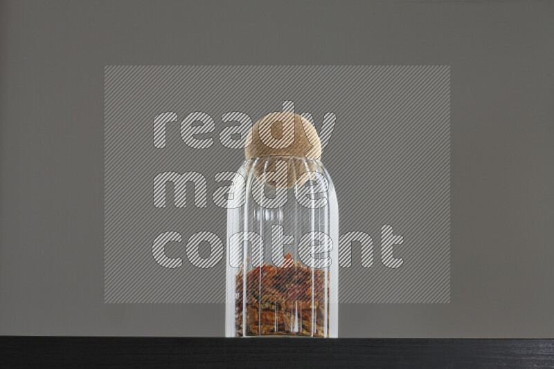 Chili pepper in a glass jar on black background