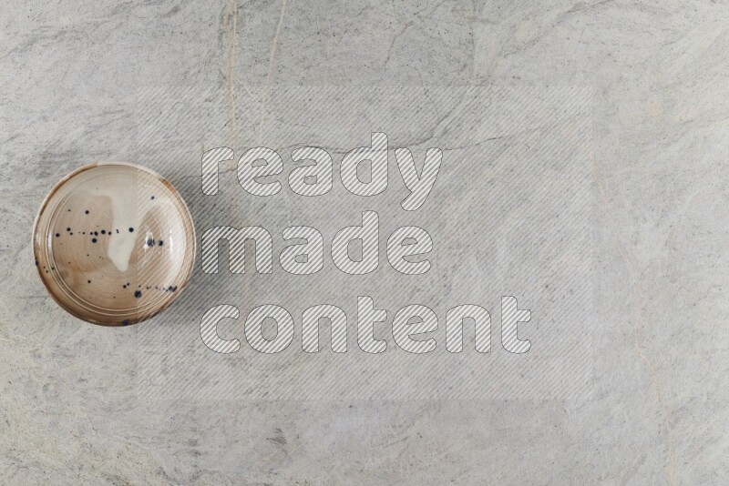 وعاء فخاري متعدد الألوان على خلفية من الرخام الرمادي