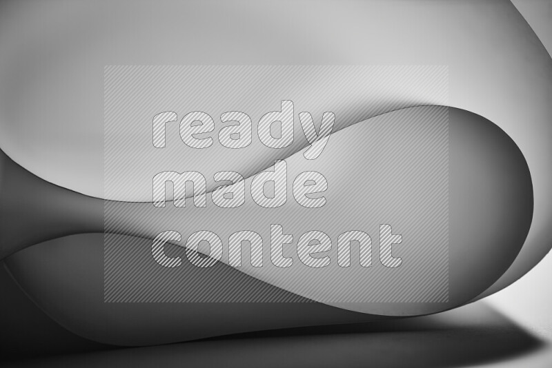 فن تجريدي يعرض منحنيات وتدرجات اللون الرمادي مكونه بضوء ملون