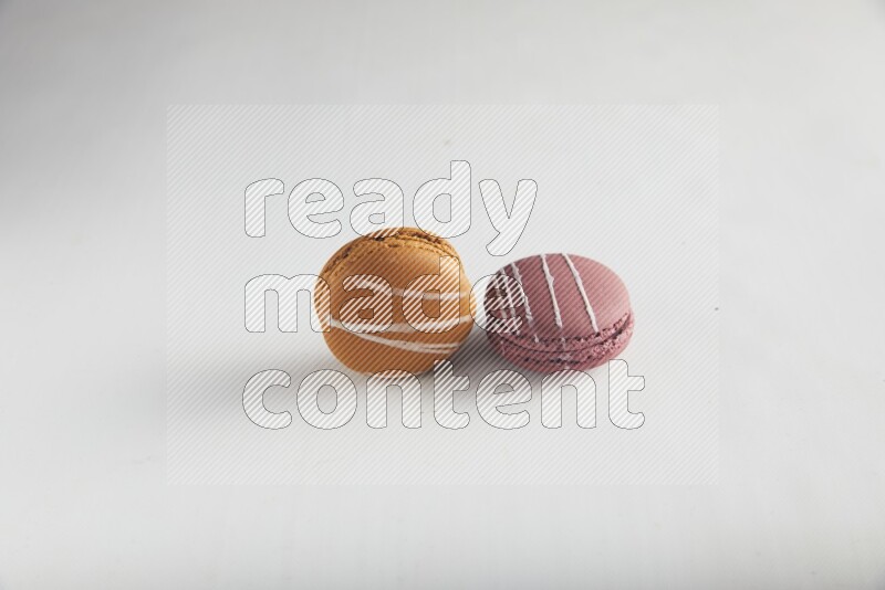45º Shot of of two assorted Brown Irish Cream, and Red Poppy Flower macarons on white background