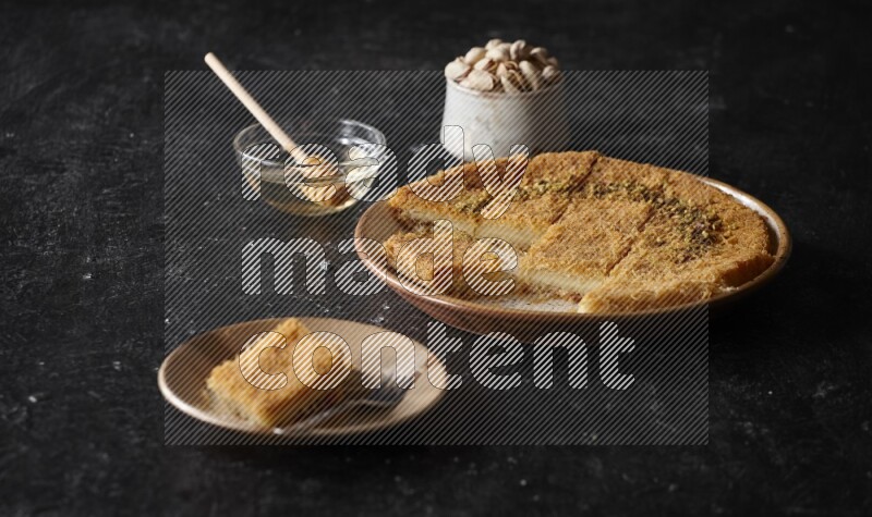 Konafa with nuts and honey in a dark setup