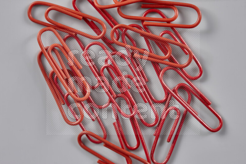 Red paper clips isolated on a grey background