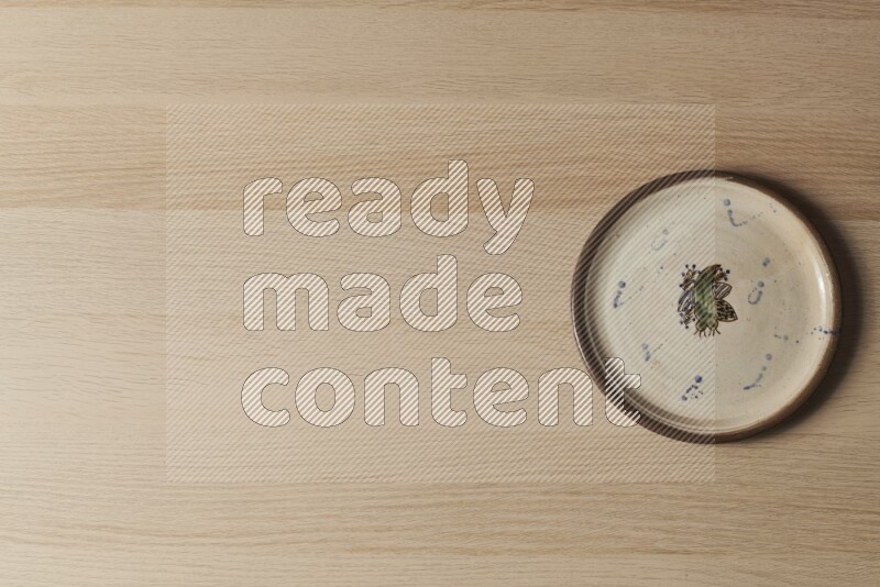 صحن فخاري مزخرف على خلفية خشبية فاتحة