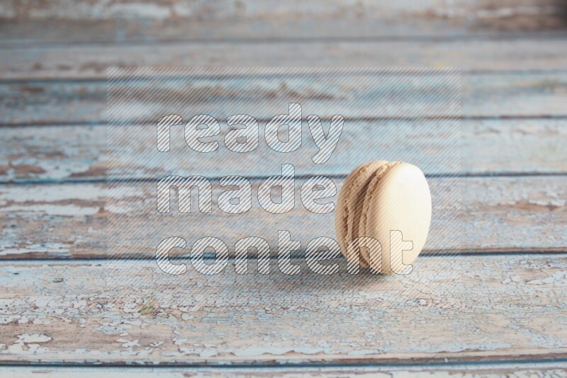 45º Shot of White Caramel fleur de sel macaron on light blue wooden background