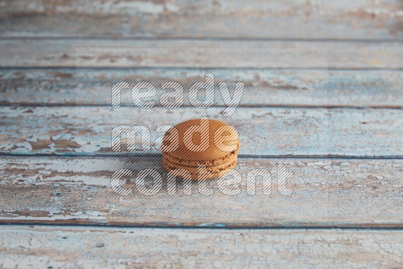 45º Shot of Brown Maple Taffy macaron on light blue wooden background