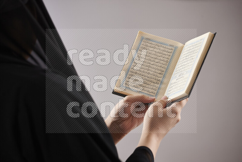 A woman hands holding moshaf in different positions