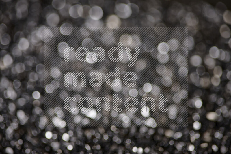 Black shimmering fragments of glass scattered on a black background