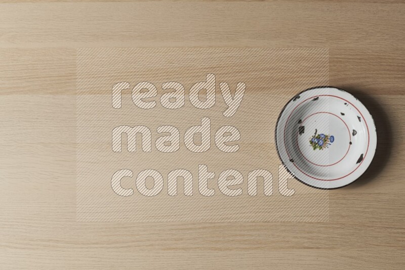 صحن معدني عتيق على خلفية خشبية فاتحة