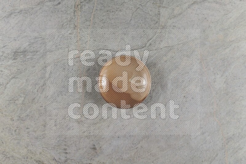 A beige pottery plate on grey marble background