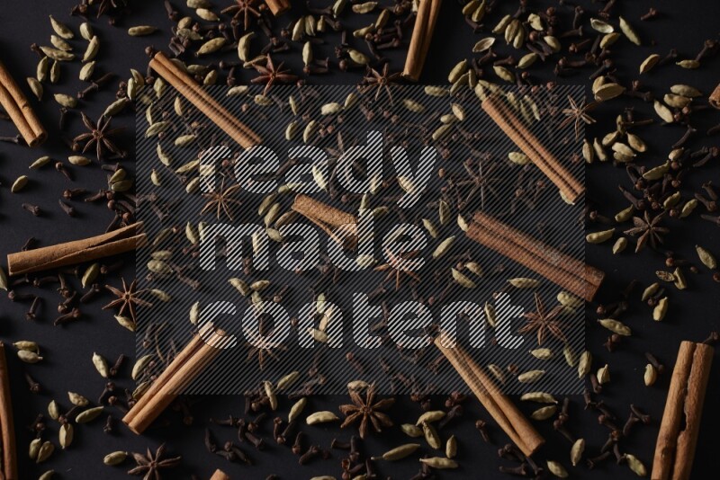 Cinnamon Sticks, Star anise, Cardamom and cloves on a black background