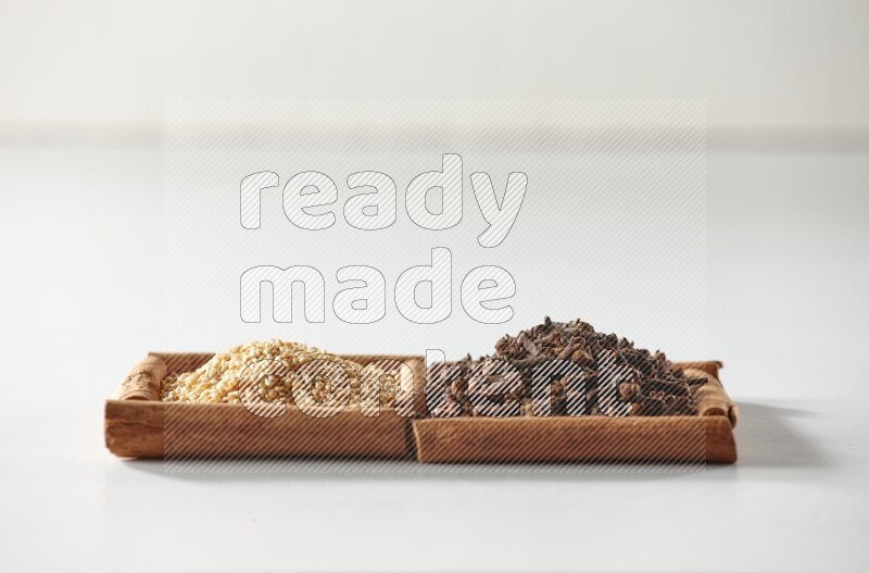 2 squares of cinnamon sticks full of cloves and sesame on white flooring