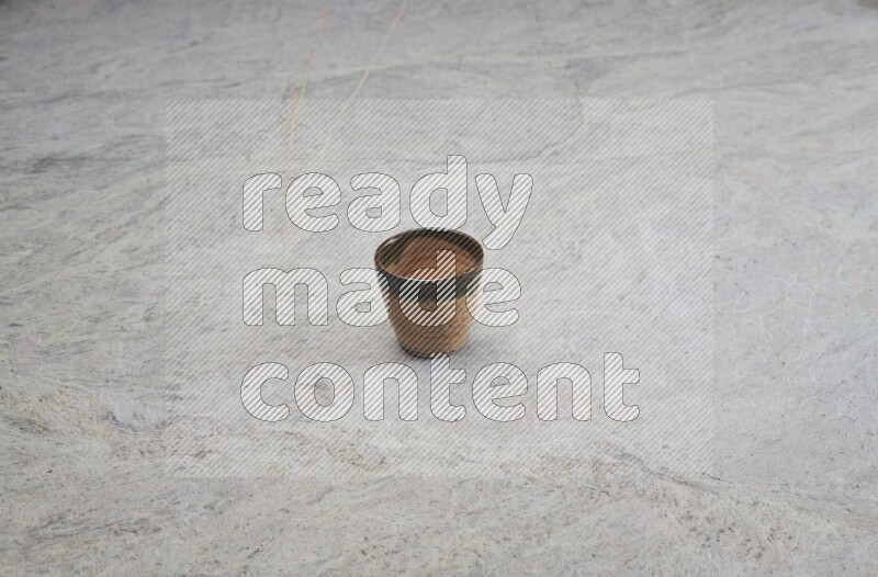 A multicolored pottery Cup on grey marble background