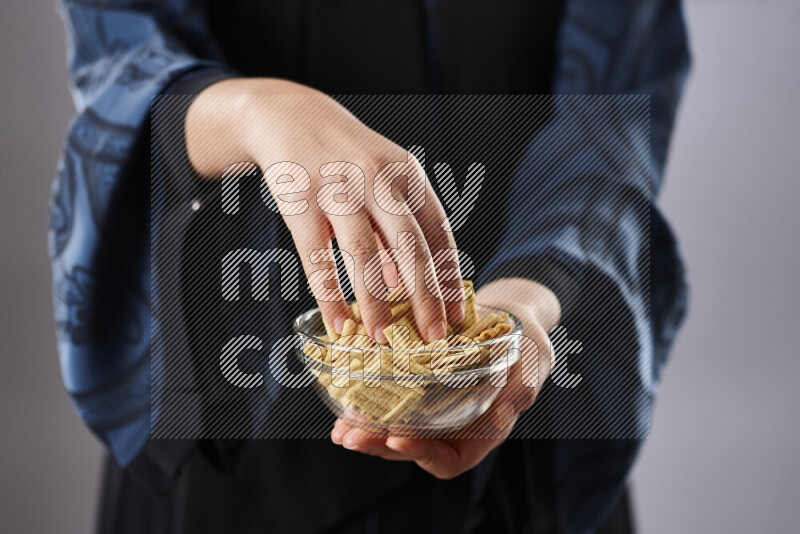Woman in abaya holding different kinds of snacks in different positions