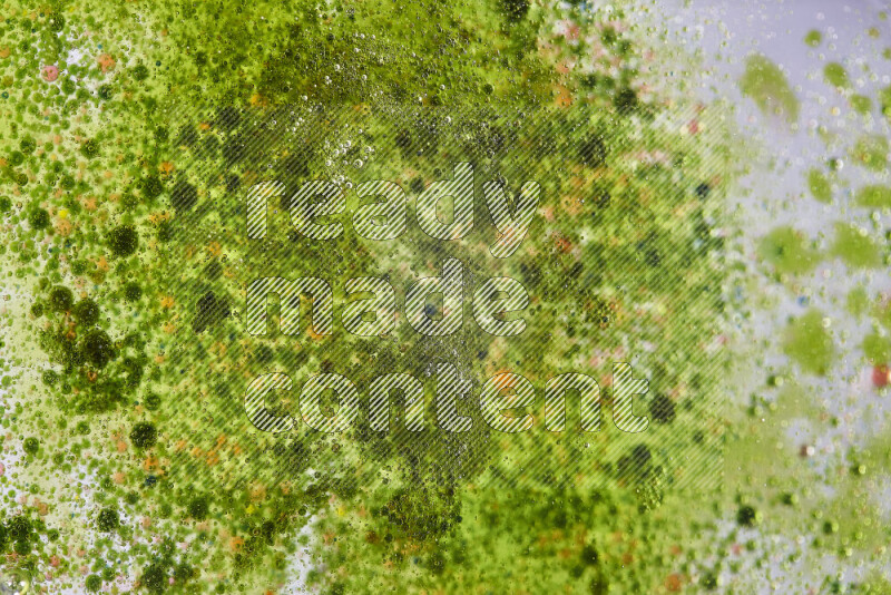 Close-ups of abstract red and green watercolor drops on oil Surface on green background