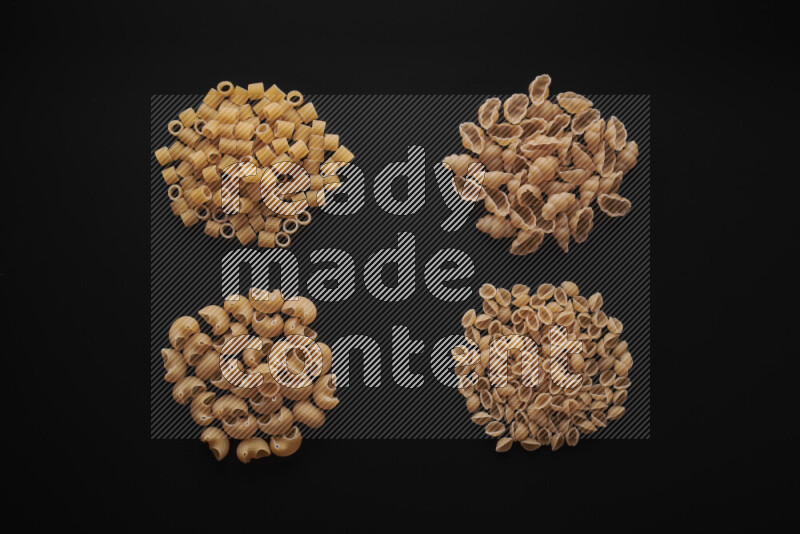 Different pasta types in bunches on black background