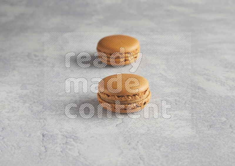 45º Shot of two Brown Maple Taffy macarons  on white  marble background