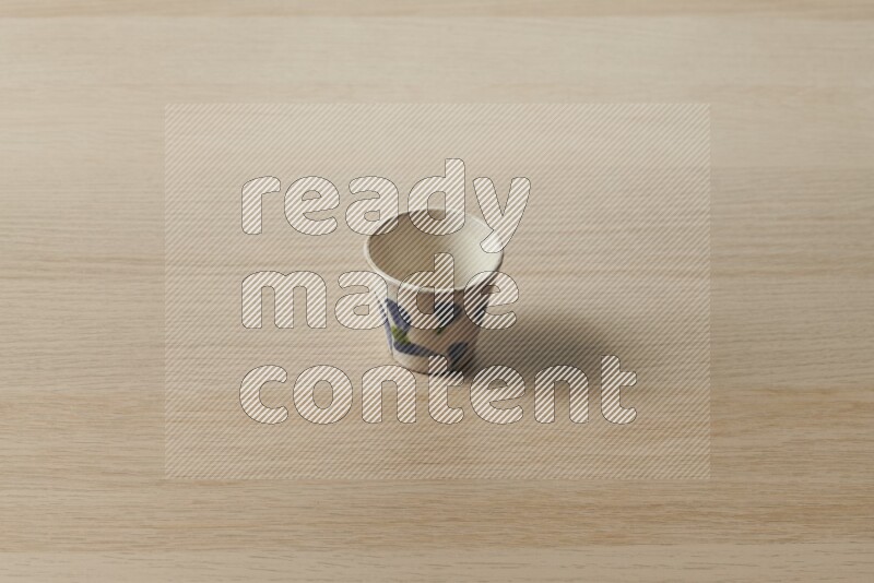 A pottery cup on light wooden background