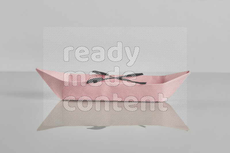 Origami boat on grey background